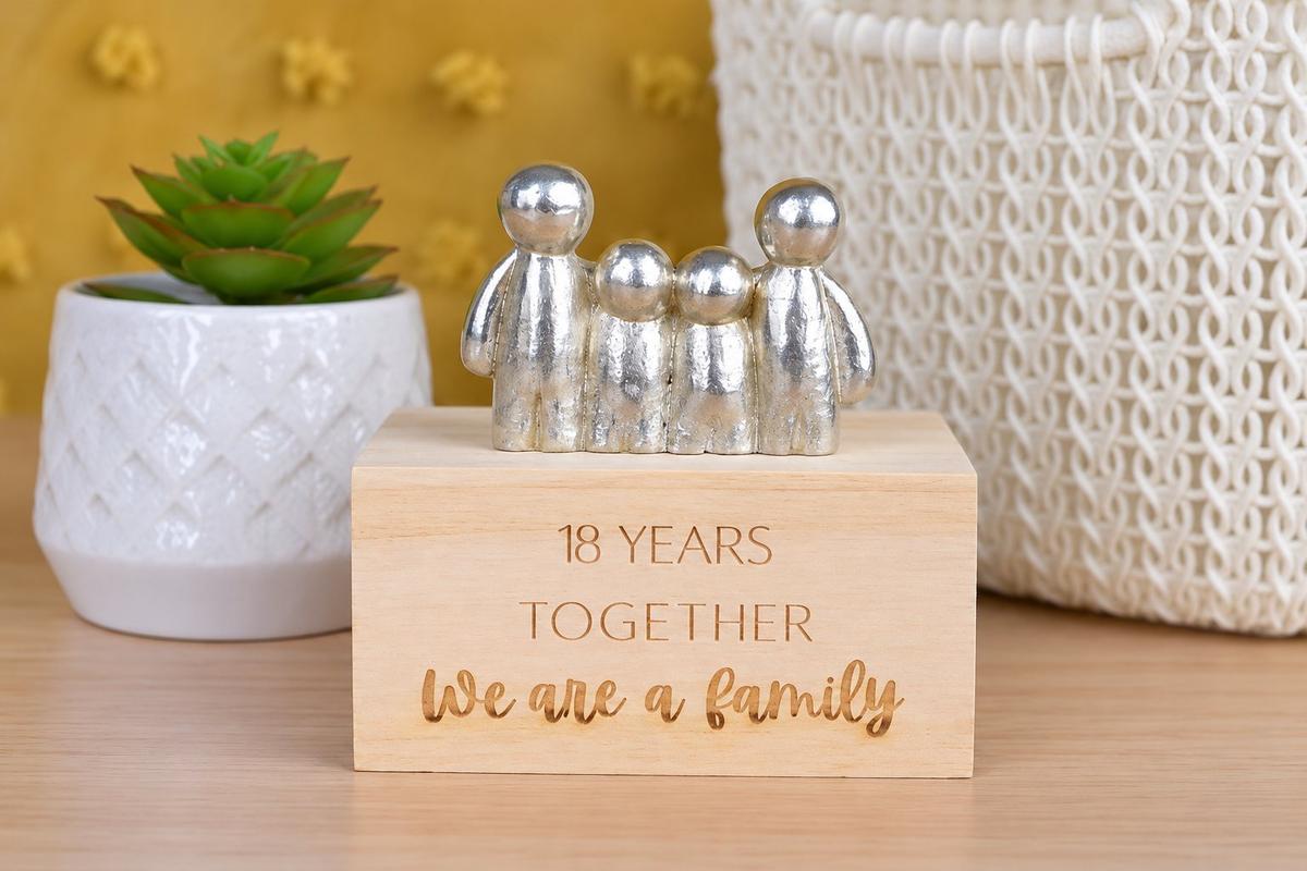 18th anniversary gift — silver-coloured family figurines on a wooden base engraved '18 Years Together We Are A Family'